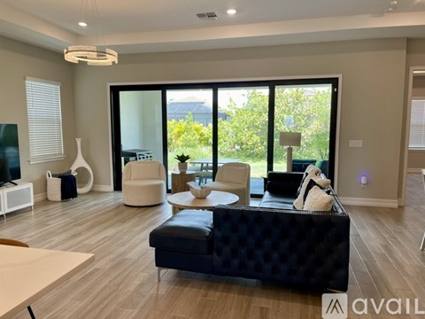A living room with a black sofa and a coffee table.