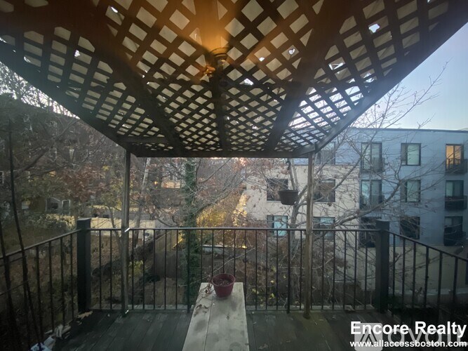 A balcony with a table and chairs overlooking a city street.