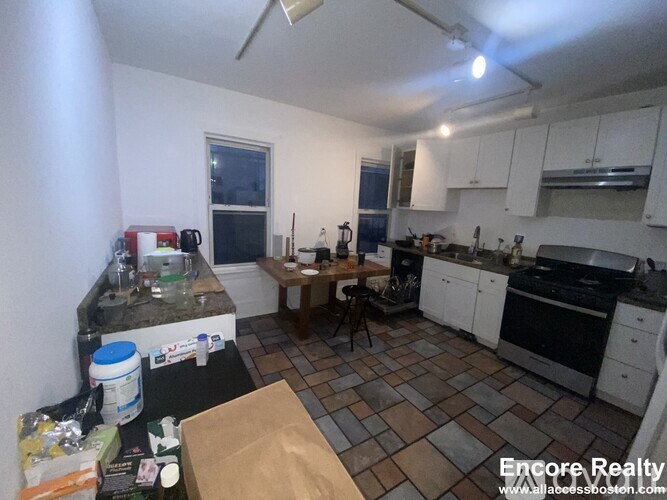 A kitchen with a table and chairs in front of it.