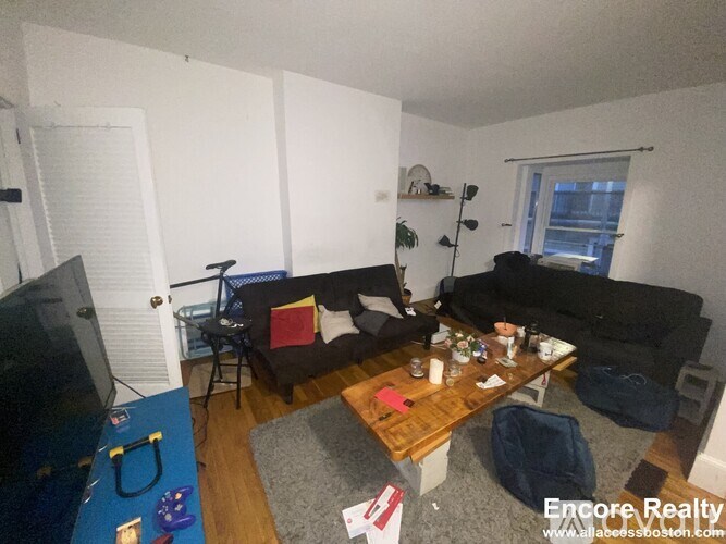 A living room with a couch, chair, and television.