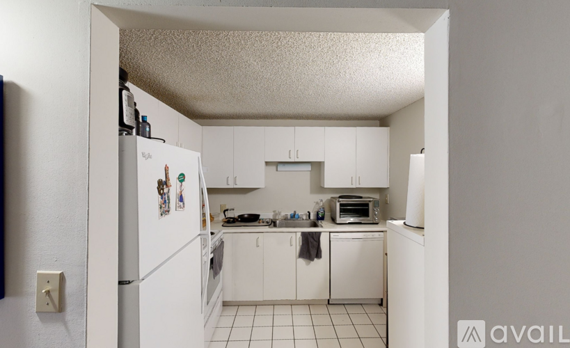 A kitchen with white appliances and cabinets.