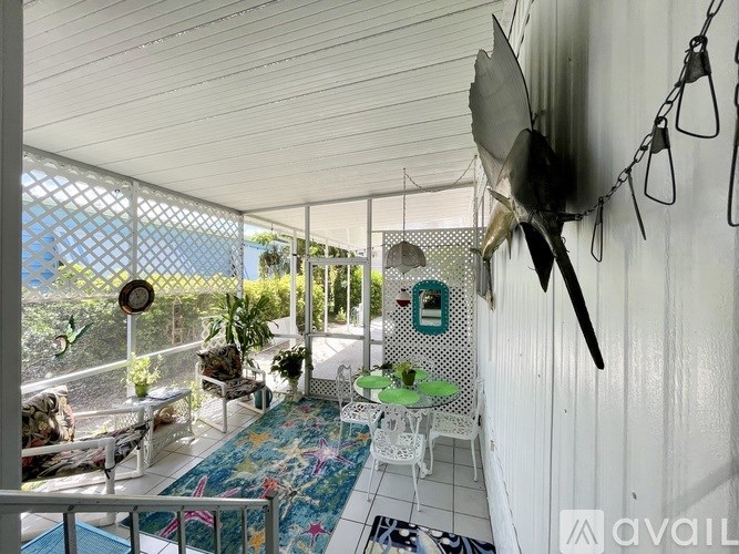 A balcony with a table and chairs overlooking a pool.