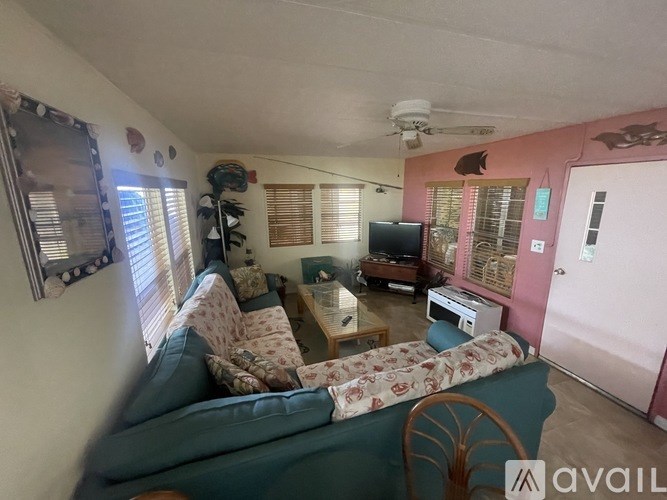 A living room with a couch, a chair, a television, and a printer on the table.