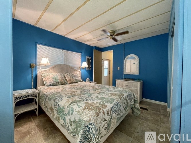 A bedroom with a bed, nightstand, and a ceiling fan.