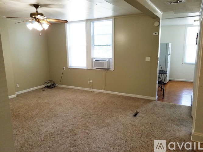 A room with a ceiling fan and carpeted floor.