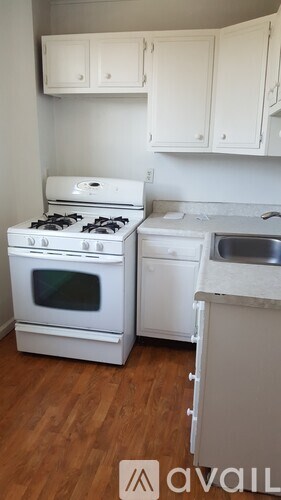 A kitchen with a white stove and a white dishwasher.