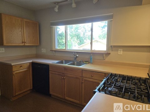 A kitchen with wooden cabinets and a black stove top.