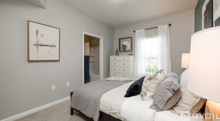A bedroom with a bed, dresser, and a painting on the wall.
