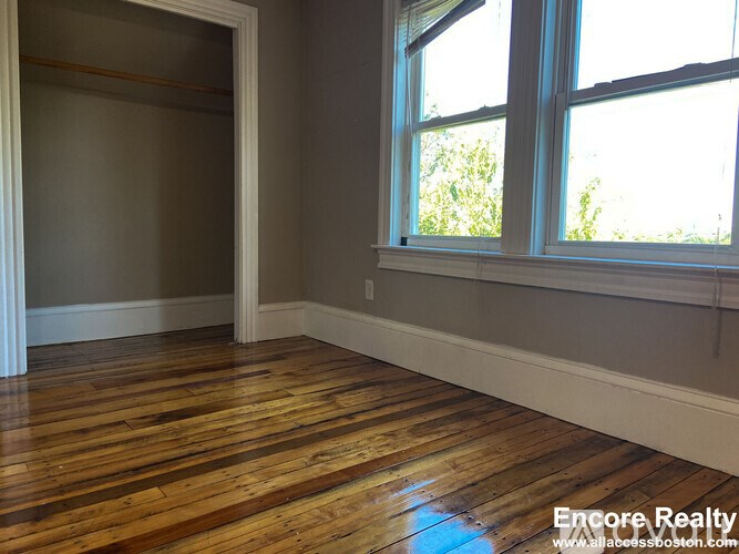 A room with wooden floors and a large window.