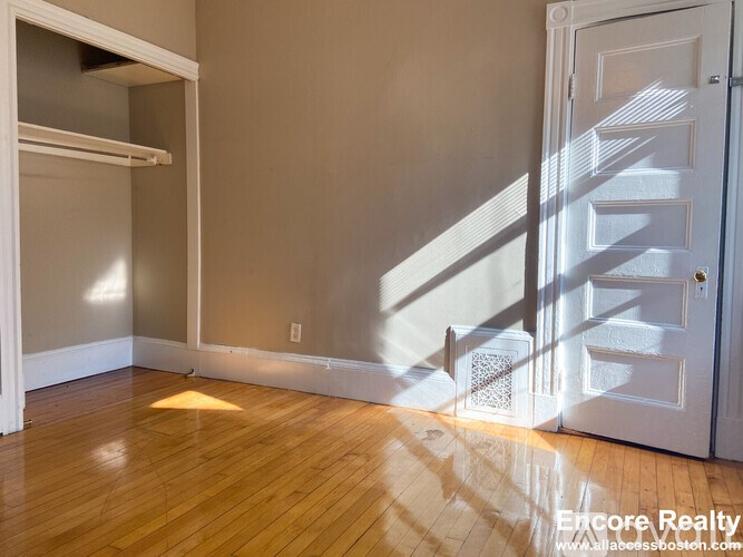 A room with wooden floors and a white door.