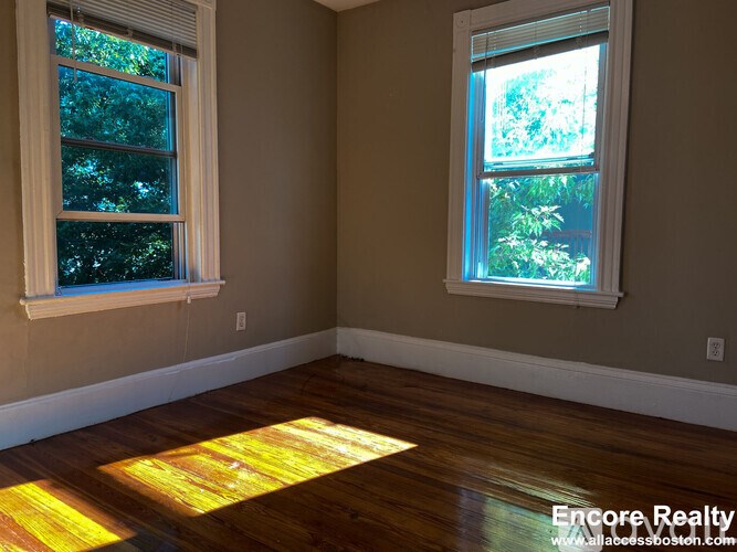 A room with two windows letting in sunlight.