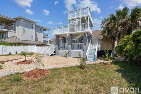 A multi-story residential building with a balcony on the top floor.