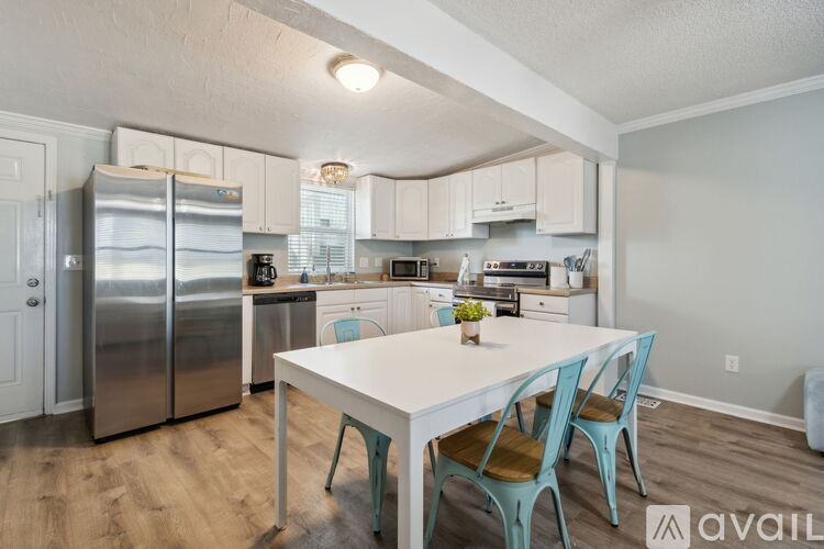 A kitchen with a table and chairs in front of it.
