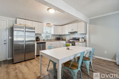 A kitchen with a table and chairs in front of it.