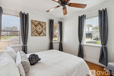 A bedroom with a large bed and a ceiling fan.