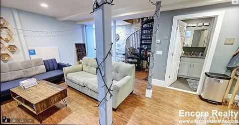 A living room with a white couch and a wooden coffee table.