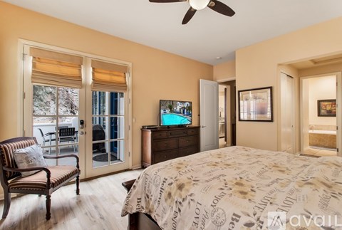 A bedroom with a large bed and a chair.