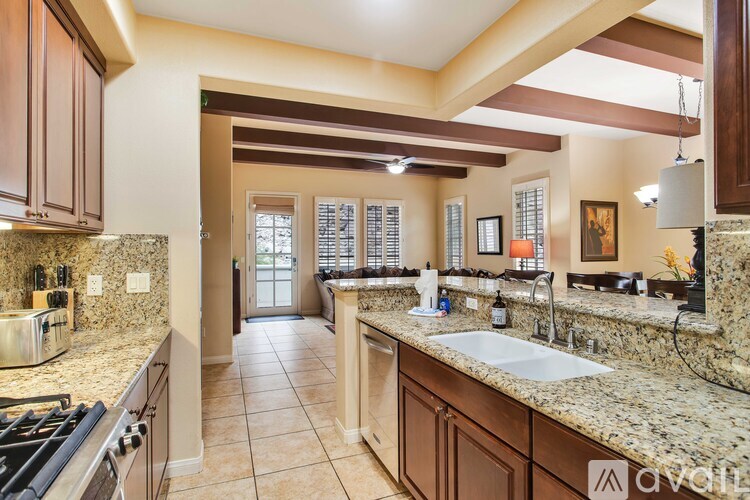 A kitchen with brown cabinets and granite countertops.