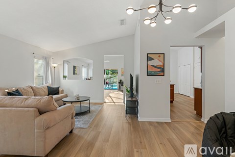 A living room with a beige couch and a glass coffee table.