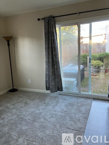 A room with wooden flooring and a window with blinds.