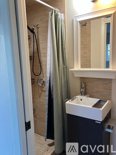 A white bathroom with a toilet, sink, and shower.