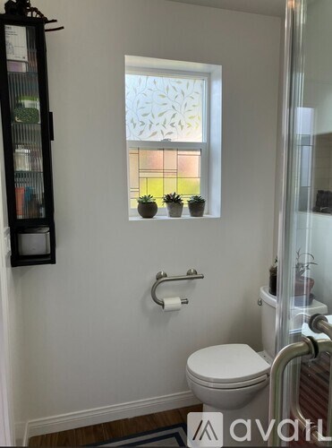 A white bathroom with a toilet, sink, and shower.