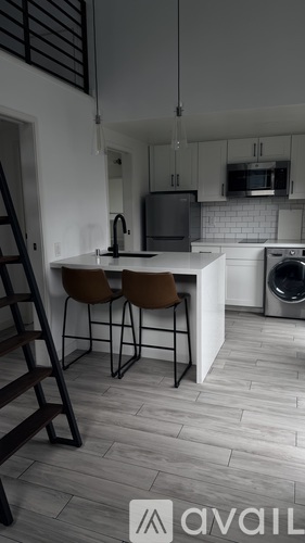 A kitchen with a washing machine and a dining table with two chairs.
