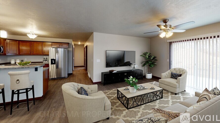 A living room with a television, couch, and chairs.
