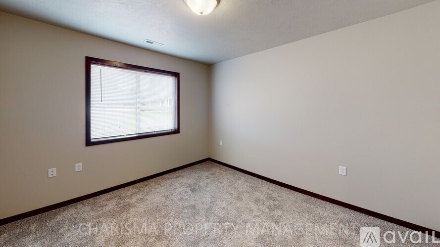 A room with a window and carpeted floor.