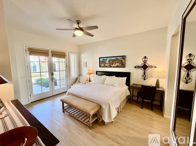 A bedroom with a large bed and a ceiling fan.