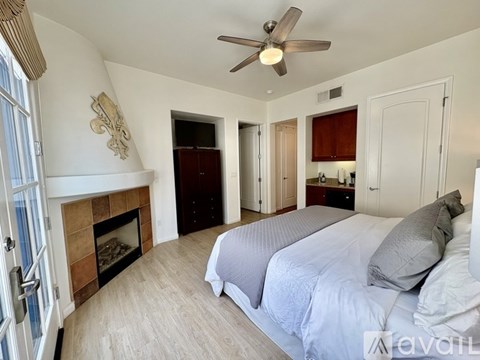 A bedroom with a large bed and a ceiling fan.