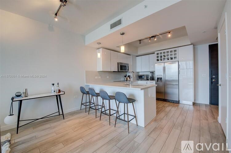 A kitchen with a bar area and a refrigerator.