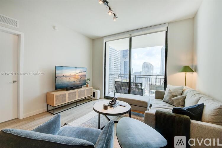 A living room with a large window overlooking a cityscape.