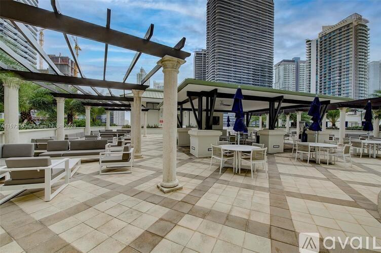 A patio area with tables and chairs under a pergola.