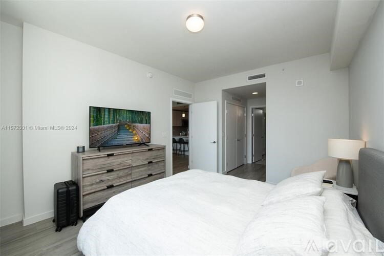 A bedroom with a bed, dresser, and painting on the wall.