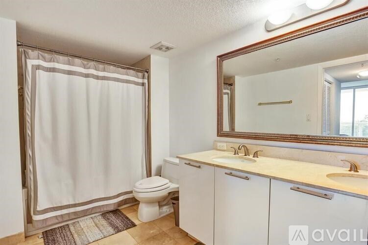 A bathroom with a toilet, sink, and mirror.