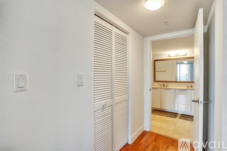 A hallway with a mirror and a wooden floor.