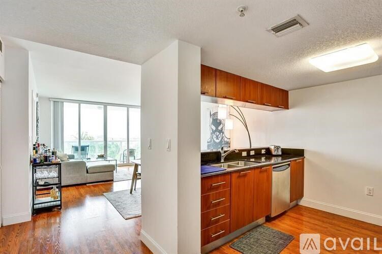 A kitchen with wooden cabinets and a large window.