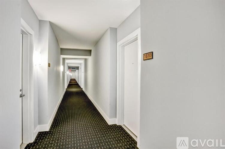 A long hallway with doors on either side and a sign on the wall.