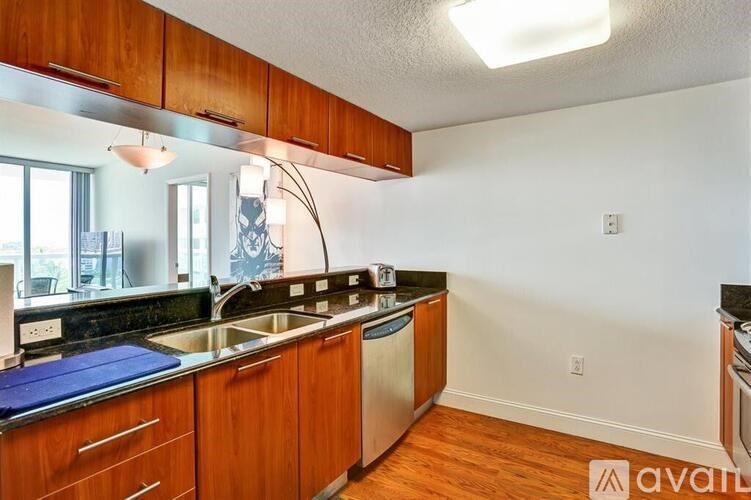 A kitchen with wooden cabinets and a stainless steel sink.