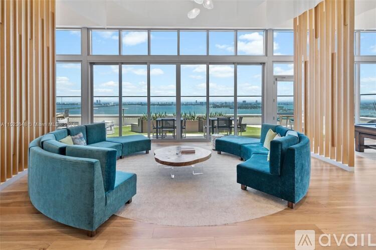 A living room with a view of the water outside the large windows.