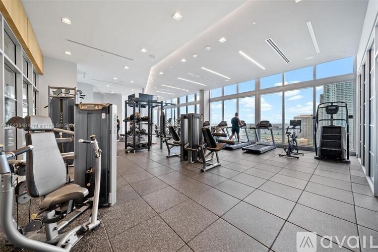 A gym with a variety of equipment including treadmills, weights, and exercise machines.