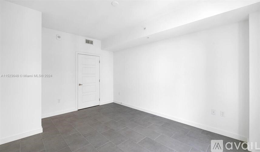 A room with a door and a wall with a small window.