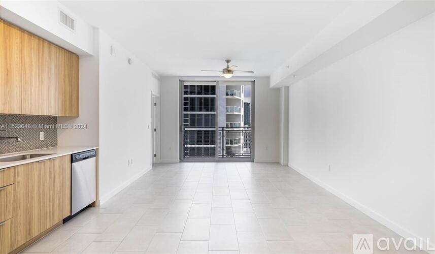 A spacious kitchen with wooden cabinets and a white interior.