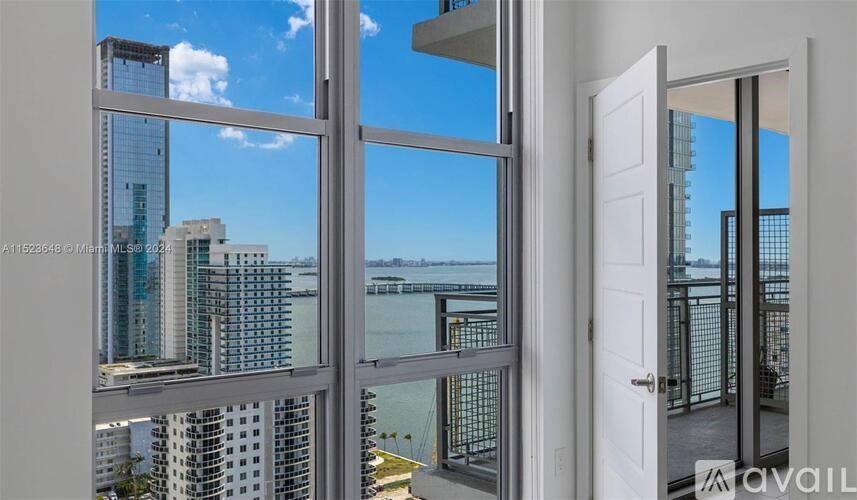 A view of a cityscape through a window with a door on the right.