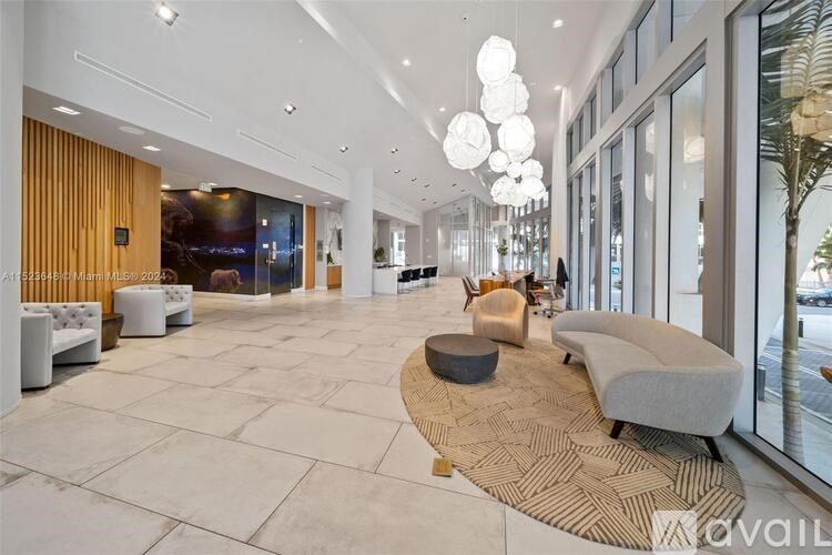 A spacious lobby with a variety of seating options and a large window overlooking the street.