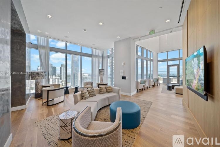 A spacious living room with a large window overlooking the city.