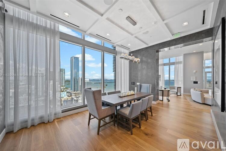 A modern dining room with a view of the cityscape.