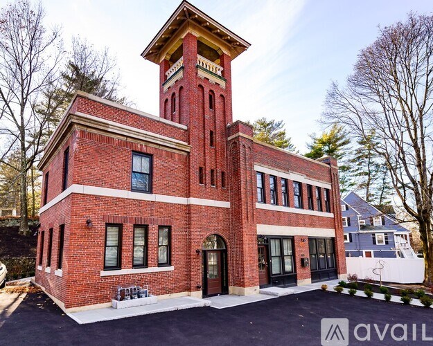 A red brick building with a tower and a clock on the top.