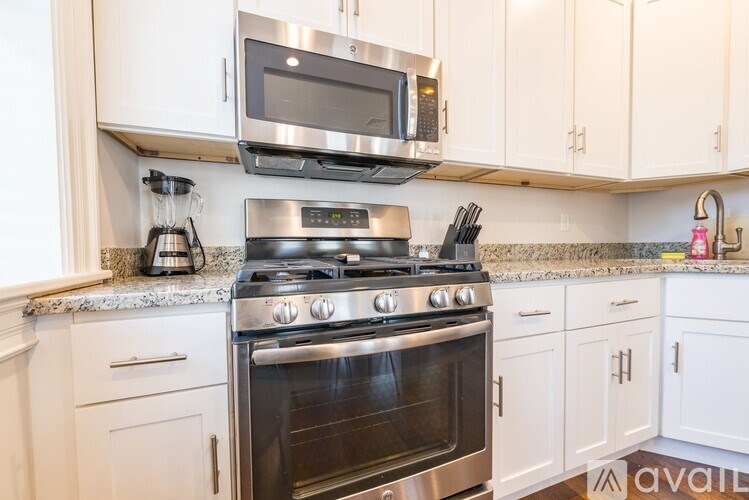 A kitchen with a stove, microwave, and oven.